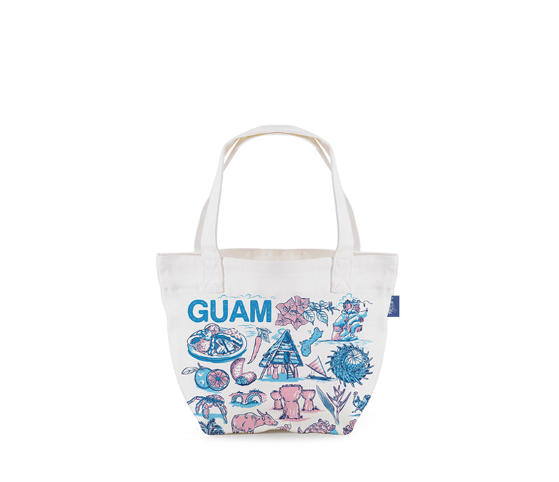 A white canvas tote bag featuring the word 'GUAM' in blue, decorated with pink and blue illustrations of tropical beach and marine life motifs, shown against a plain white background.