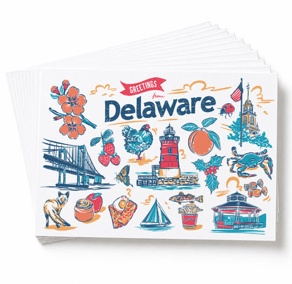 A stack of Delaware-themed greeting cards fanned out on a white background. The front card features colorful illustrated landmarks and symbols including the Delaware bridge, lighthouse, blue crab, orange, cat, pizza, and a red banner reading 'Greetings from Delaware'.