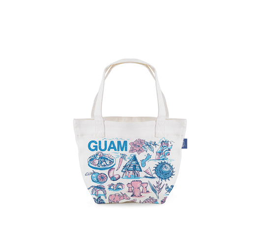A white canvas tote bag featuring the word 'GUAM' in blue, decorated with pink and blue illustrations of tropical beach and marine life motifs, shown against a plain white background.