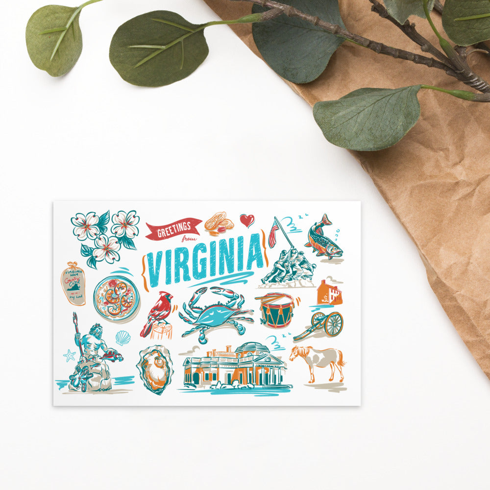 A rectangular printed card featuring colorful illustrated landmarks and symbols of Virginia, styled on a white surface with brown paper and green leaves in the corner.