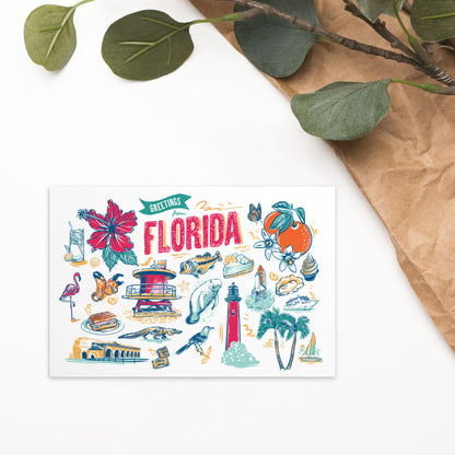 A square greeting card with a colorful hand-drawn Florida collage, styled on a white surface with brown paper and green leaves in the corner.